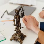 Scales of justice statue on a desk with legal documents, representing tax planning for attorneys and law firm owners