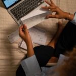 Person reviewing a paycheck and payroll paperwork
